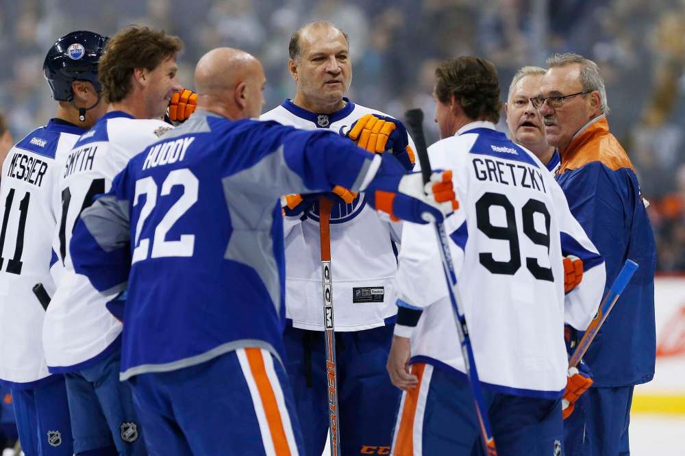 John Woods / The Canadian Press
Former Edmonton Oilers Dave Semenko, centre, and others listen in as captain Wayne Gretzky (99) leads a huddle during a practice for the NHL's Heritage Classic Alumni game in Winnipeg on Friday.