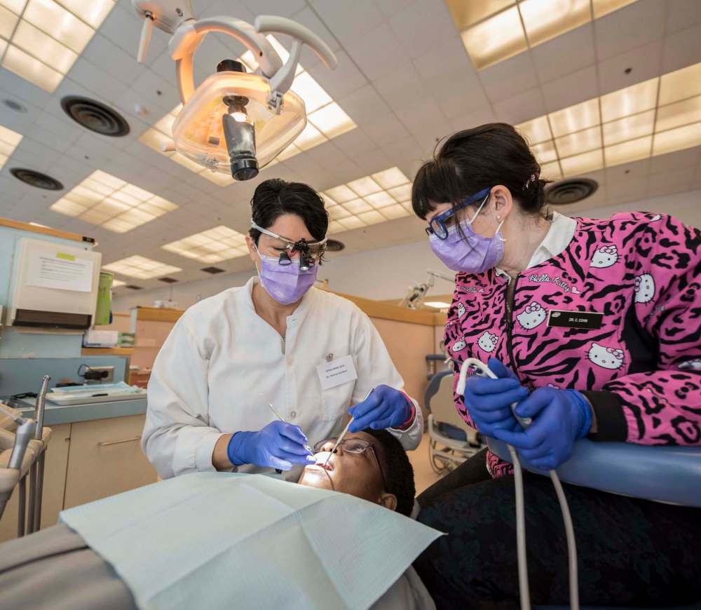 DAVID LIPNOWSKI / WINNIPEG FREE PRESS
Dr. Karina Gamboa (left) and Dr. Carla Cohn work on Mwashite Mbekalo of Tanzania at the University of Manitoba’s College of Dentistry. The Manitoba Dental Association and the University of Manitoba’s College of Dentistry hosted ‘Open Wide’, a day of free dental services for refugees.