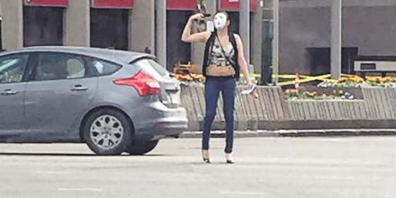 ALEXIS DEVITO PHOTO FILESStunned onlookers watch as a girl donned a white mask and wandered through traffic at Portage and Main with a firearm that turned out to be a black-painted BB gun.