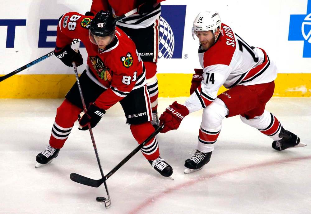 Nam Y. Huh / The Associated Press
Chicago Blackhawks right wing Patrick Kane, left, controls the puck against Carolina Hurricanes defenseman Jaccob Slavin during the second period.