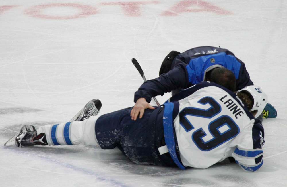 JEFFREY BARNES / THE ASSOCIATED PRESS
Patrik Laine is helped by a trainer after getting hit during the third period against the Buffalo Sabres.