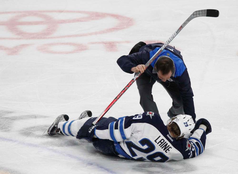 JEFFREY T. BARNES / AP
Winnipeg Jets forward Patrik Laine (29) is helped by a trainer after being hit during the third period of an NHL hockey game against the Buffalo Sabres, Saturday.