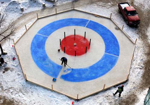 BORIS MINKEVICH / WINNIPEG FREE PRESS
>Visual artist James Culleton, centre, and The Forks manager of special projects Dave Pancoe, are dwarfed by the size of the Crokicurl playing surface.