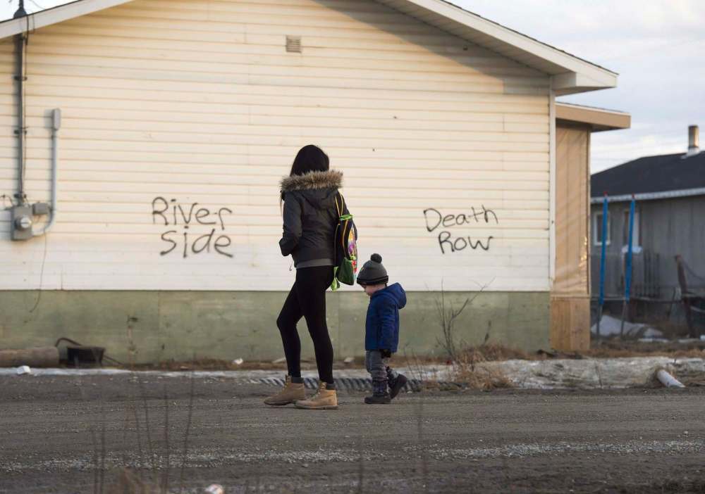NATHAN DENETTE / THE CANADIAN PRESS FILES
A woman and young boy walk through the streets in the northern Ontario First Nations reserve in Attawapiskat, Ont.