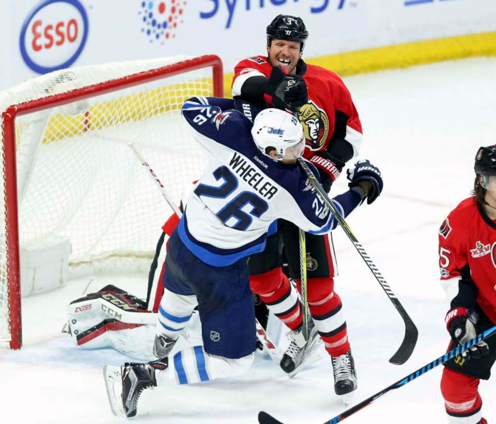 Fred Chartrand / The Canadian Press
Blake Wheeler takes is shoved by Ottawa Senators' Marc Methot in front of the Senators' net during the second period.