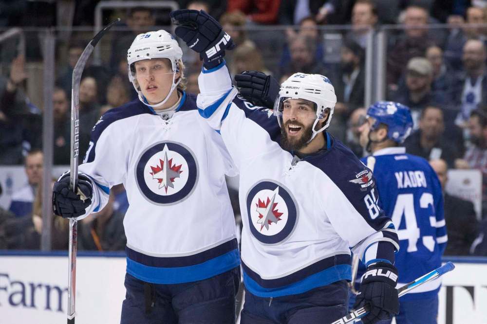 CHRIS YOUNG / THE CANADIAN PRESS
Winnipeg Jets right wing Patrik Laine, left, celebrates with Mathieu Perreault after scoring his team's opening goal during first period NHL hockey action against the Toronto Maple Leafs, in Toronto on Tuesday.