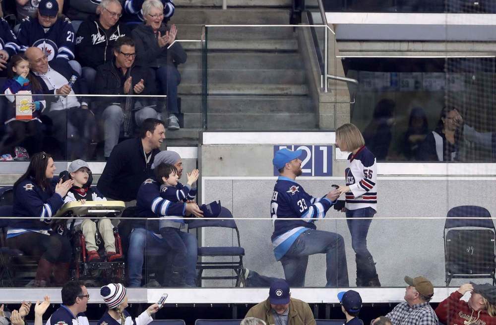 TREVOR HAGAN / THE CANADIAN PRESS
A Winnipeg Jets fan proposes to his partner as the team plays the Minnesota Wild during the first period of Tuesday's game in Winnipeg.