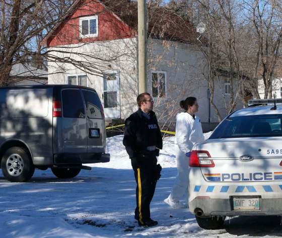 WAYNE GLOWACKI / WINNIPEG FREE PRESS FILESRCMP officers at the scene of a double homicide at a house (background) in St-Georges.