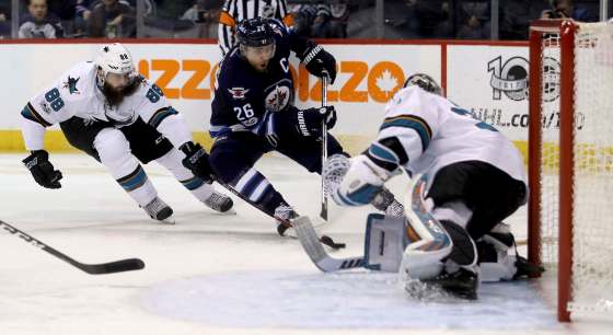 TREVOR HAGAN / THE CANADIAN PRESSSan Jose Sharks Brent Burns tries to knock the puck off the stick of Winnipeg Jets Blake Wheeler in front of Sharks goaltender Aaron Dell Monday at the MTS Centre.