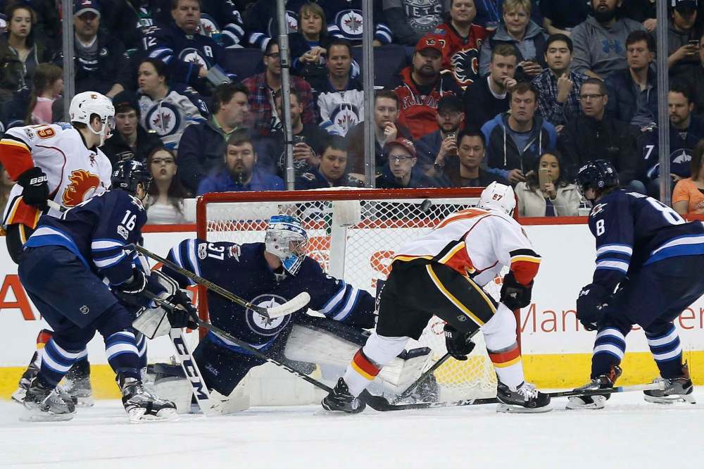 John Woods / The Canadian Press
Calgary Flames penalty-kill specialist Michael Frolik can also bulge the twine, scoring on Winnipeg Jets goalie Connor Hellebuyck during second-period NHL action at the MTS Centre Saturday night.