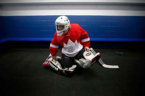 PHOTOS BY JOHN WOODS / WINNIPEG FREE PRESS
Bob James, who rents himself out to teams that are in need of a goalie, straps on the pads before a game at Canlan ice rink
