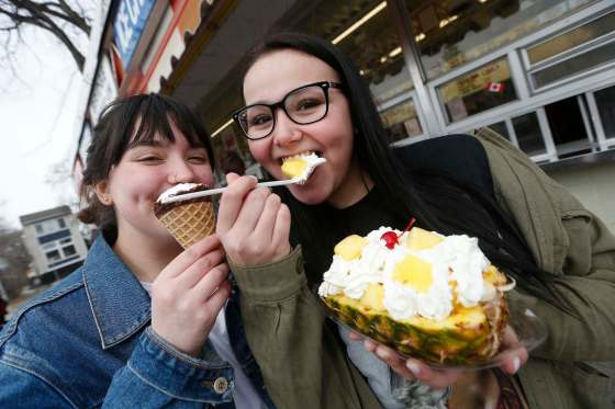 JOHN WOODS / WINNIPEG FREE PRESSFaith Sobotkiewicz (left) and Lyric Lupichuk chow down on a Saltzberg and Sleeping Beauty as they get the first taste of summer at the Bridge Drive-In (BDI) Sunday.