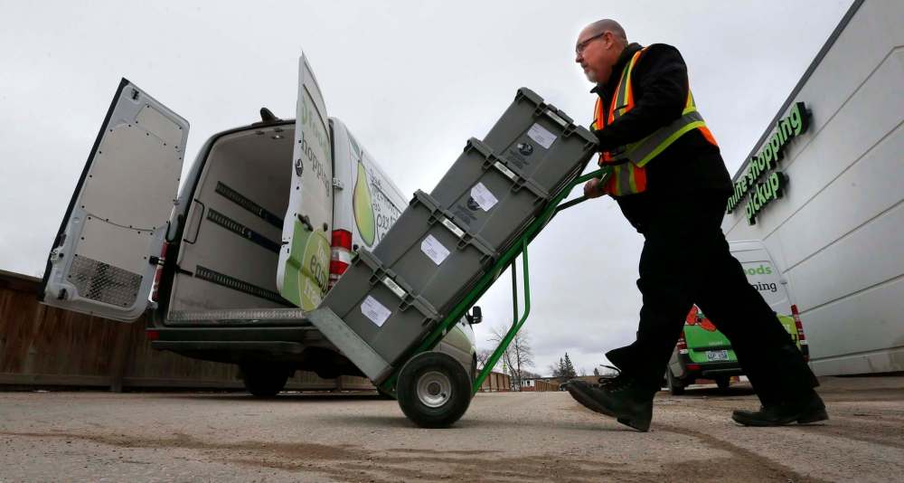 WAYNE GLOWACKI / WINNIPEG FREE PRESS
McLennan moves several crates containing online delivery orders from the store to a van at Save-On-Foods in the Northgate shopping centre on McPhillips Street.