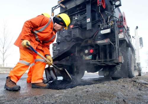 WAYNE GLOWACKI / WINNIPEG FREE PRESS FILES
City crews repair a pothole on Empress Street in 2014. Empress is among the worst roads in Winnipeg according to a CAA poll.