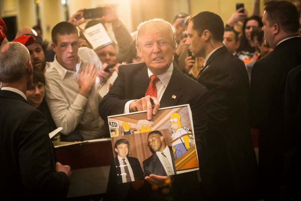 JOHN MINCHILLO / ASSOCIATED PRESS FILES
Then-Republican presidential candidate Donald Trump holds depictions of himself on The Simpsons and a photo with boxer Mike Tyson, given to him by an attendee during a campaign stop in 2016.