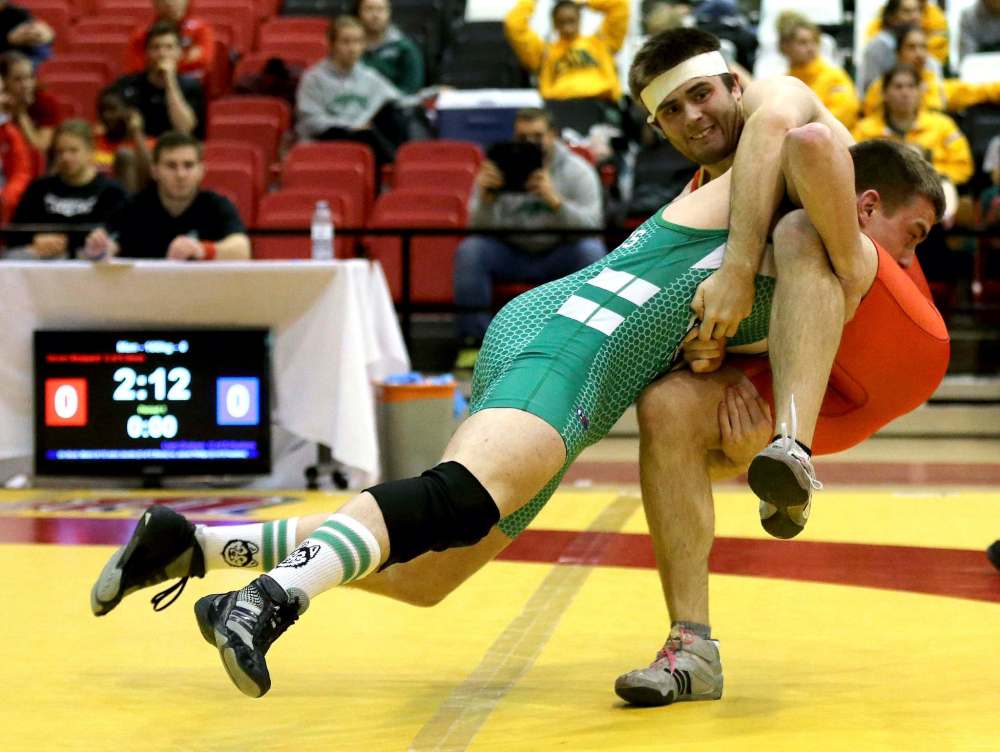 University of Saskatchewan's Liam Graham, left, wrestles University of Calgary's Steven Sheppard, during wresting during the Canada West Wrestling Championships at the University of Winnipeg, Saturday, Feb. 13, 2016. The University of Winnipeg announced it is suspending wrestling and other sports.