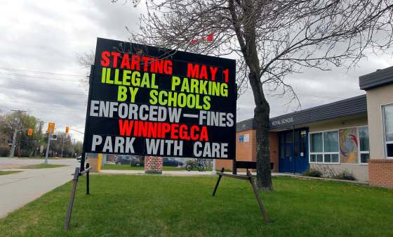 A sign outside Royal School alerts parents to the new attention to parking enforcement. (Boris Minkevich / Winnipeg Free Press)