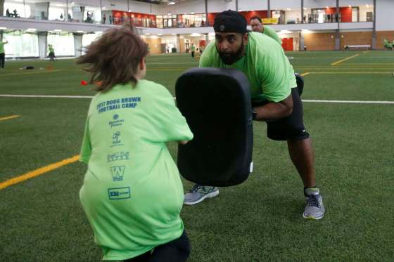 Former Blue Bomber Obby Khan holds the bag during a drill for the young players at the Doug Brown KidSport Winnipeg Football Camp at the University of Winnipeg Sunday. (John Woods / Winnipeg Free Press)