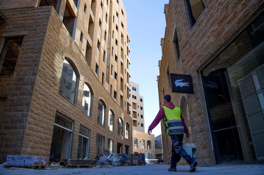 Linda Davidson / Washington Post
A construction worker in Rawabi walks by a store that will sell goods from Lacoste.
