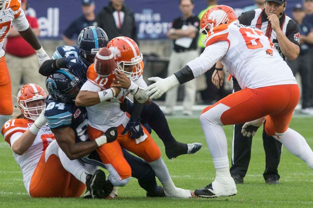 Chris Young / The Canadian Press
B.C. Lions quarterback Jonathon Jennings is sacked by Toronto Argonauts defender Victor Butler during Week 2 action in Toronto.