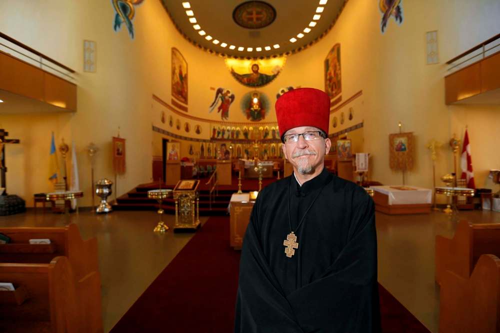 JUSTIN SAMANSKI-LANGILLE / WINNIPEG FREE PRESS
Rev. Eugene Maximiuk of Holy Trinity Ukrainian Orthodox Metropolitan Cathedral poses in front of the altar and the cathedral’s restored icon paintings.