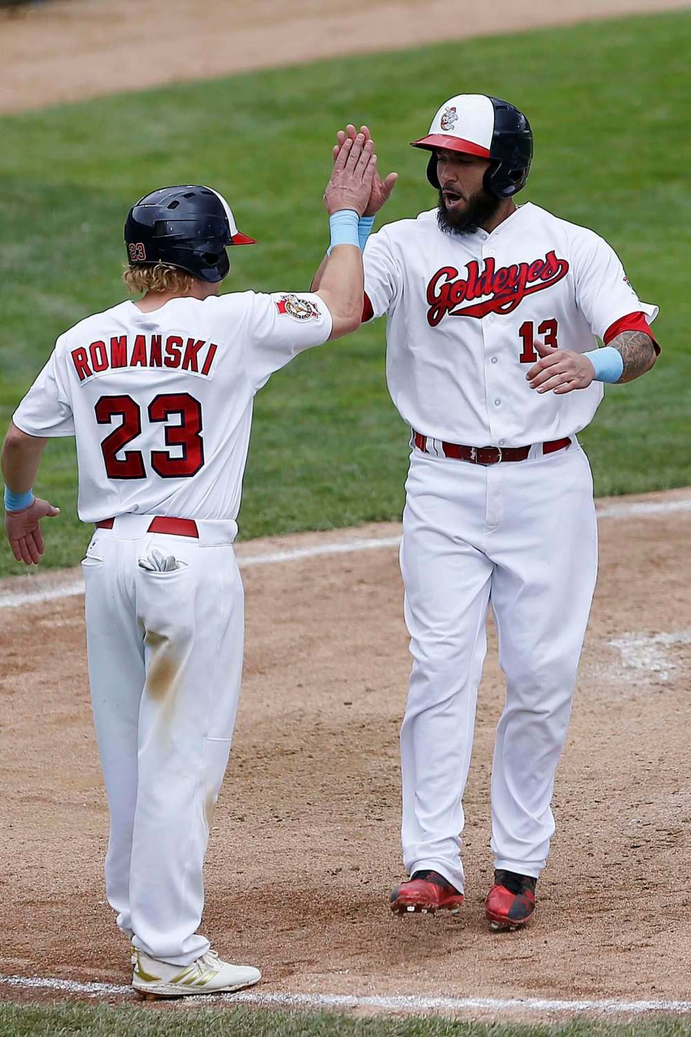 JOHN WOODS / WINNIPEG FREE PRESS FILES
The Goldeyes' Josh Romanski (23) and David Bergen (13) celebrate scoring against the Saints.