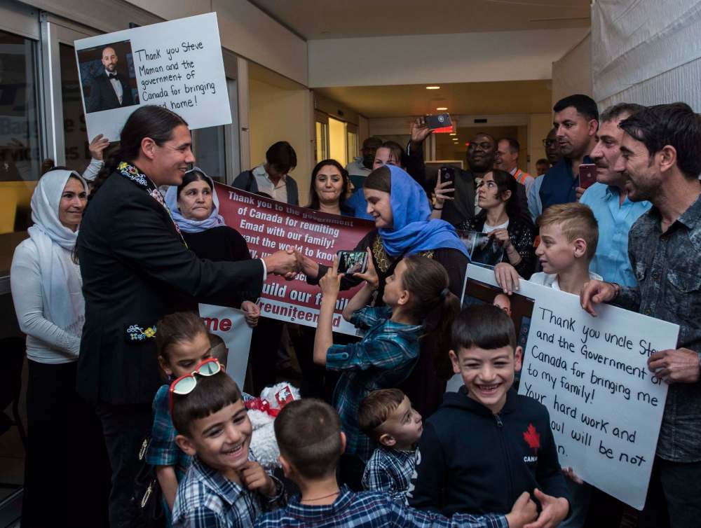 David Lipnowski / The Canadian Press
Liberal MP Robert-Falcon Ouellette, left, greets mother Nofa Mihlo Rafo as friends and family are reunited with 12-year-old Emad Mishko Tamo, third from right, at Winnipeg's James Armstrong Richardson International Airport, early Thursday.