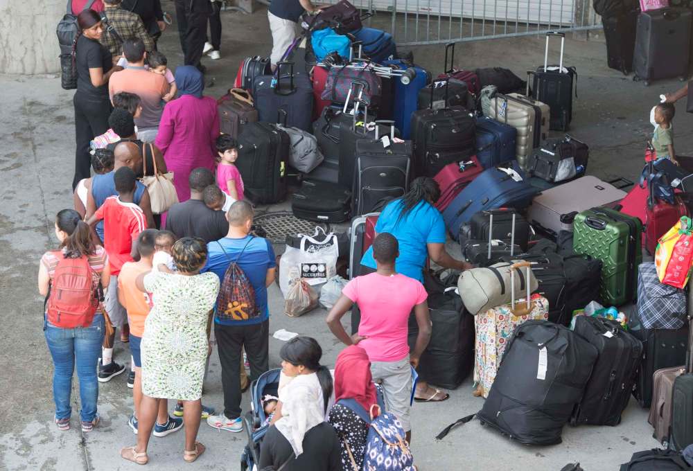 Paul Chiasson / The Canadian Press
Asylum seekers wait to enter Olympic Stadium in Montreal last month.
