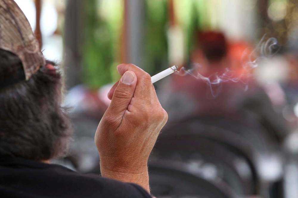 RUTH BONNEVILLE / WINNIPEG FREE PRESS
A person smokes a cigarette on a patio on Corydon Avenue.