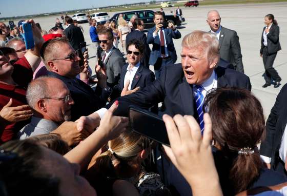 Pablo Martinez Monsivais / The Associated PressPresident Donald Trump reaches out to greet supports on the tarmac upon his arrival at Bismark Municipal Airport, Wednesday, Sept. 6, 2017 in Bismark, N.D. Trump is in North Dakota to promote his tax overhaul plan.