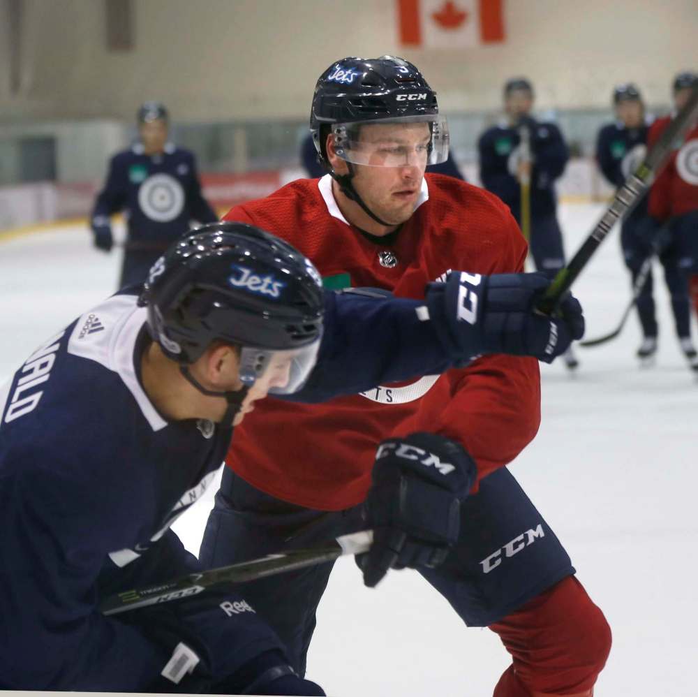 WAYNE GLOWACKI / WINNIPEG FREE PRESS
Tucker Poolman (right) ties up Kody McDonald at the Jets camp Thursday.
