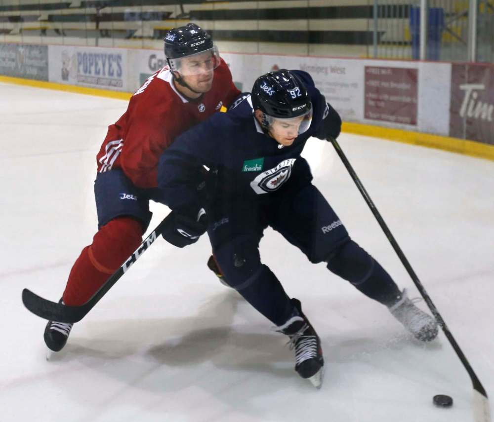 WAYNE GLOWACKI / WINNIPEG FREE PRESS
At left, Tucker Poolman ties up Kody McDonald at the Winnipeg Jets camp at the BellMTS Iceplex Thursday. Jason Bell story Sept. 7 2017