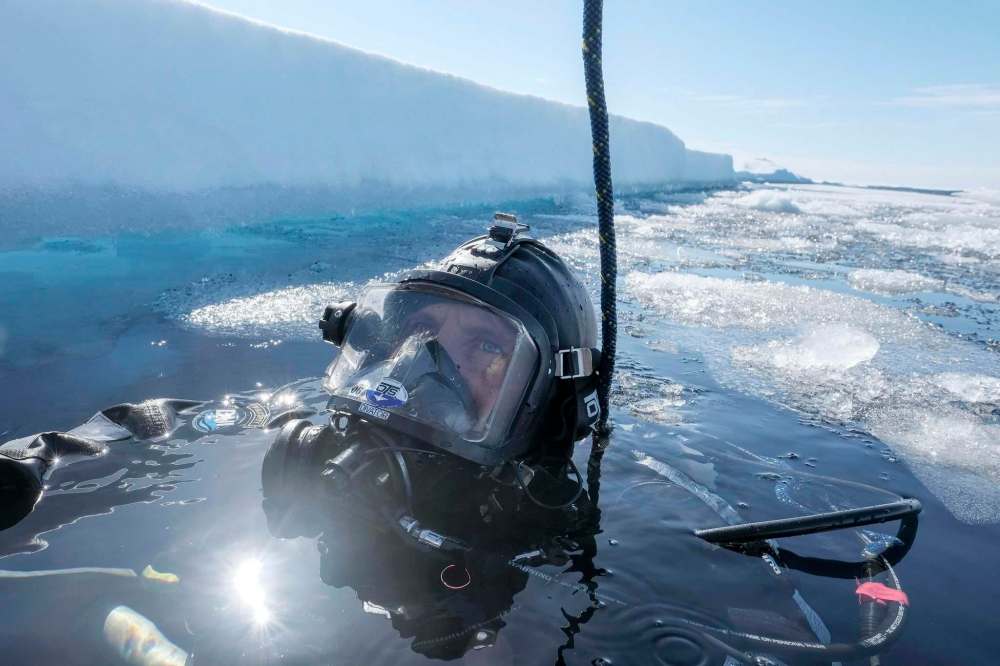 Photos by Bonnie Jo Mount / Washington Post Files
Chief Petty Officer Chuck Ashmore, a diver with the U.S. Coast Guard, waits for his dive partner to enter the water to explore beneath ice in the Arctic Ocean.