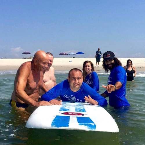 James Mulvaney
Dan Mulvaney (centre), who has a rare form of autism, has found joy on a surfboard. Surrounding him (left to right) are family friend Harvey Weisenberg, his father James Mulvaney and two surf instructors.