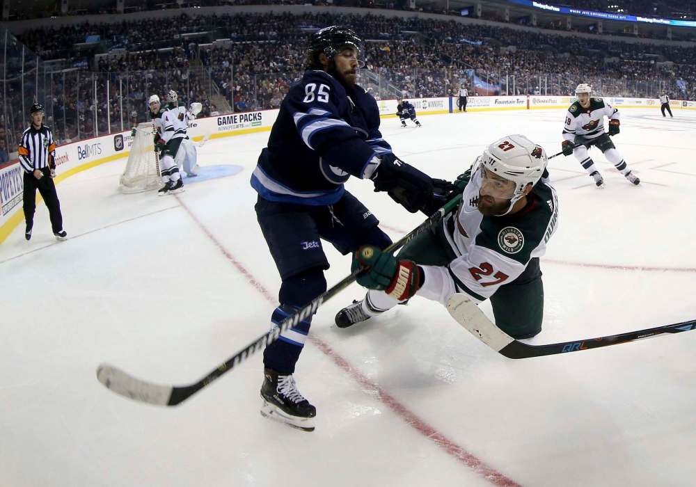 THE CANADIAN PRESS/Trevor Hagan
Winnipeg Jets forward Mathieu Perreault hits Minnesota Wild defenceman Kyle Quincy during second period NHL pre-season hockey action in Winnipeg, Monday.