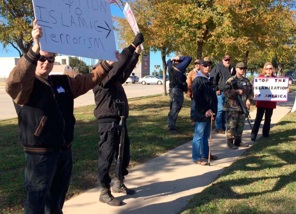 Armed demonstrators hold a protest outside the Islamic Center of Irving in the Dallas suburb of Irving, Texas. The movement has rallied against gun control efforts, patrolled the border with Mexico and recently begun confronting Muslim Americans. (Avi Selk/The Dallas Morning News via AP)