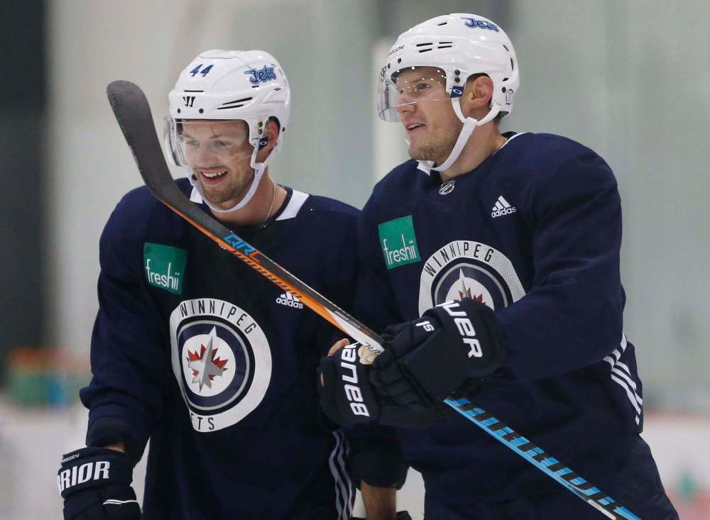 JOHN WOODS / THE CANADIAN PRESS FILES
Winnipeg Jets defencemen Josh Morrissey (left) and Dmitry Kulikov chat during speed trials at training camp in Winnipeg in late September.