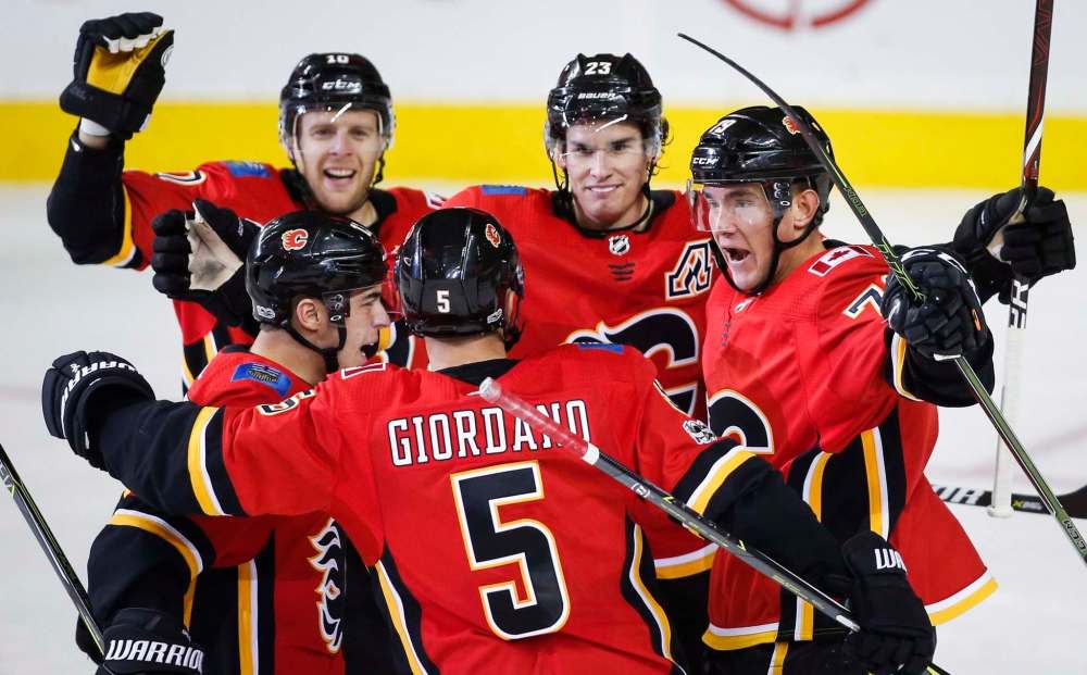 JEFF MCINTOSH / THE CANADIAN PRESS
Calgary Flames' Micheal Ferland, right, celebrates his goal with teammates during second period NHL hockey action against the Winnipeg Jets in Calgary, Saturday, Oct. 7, 2017.