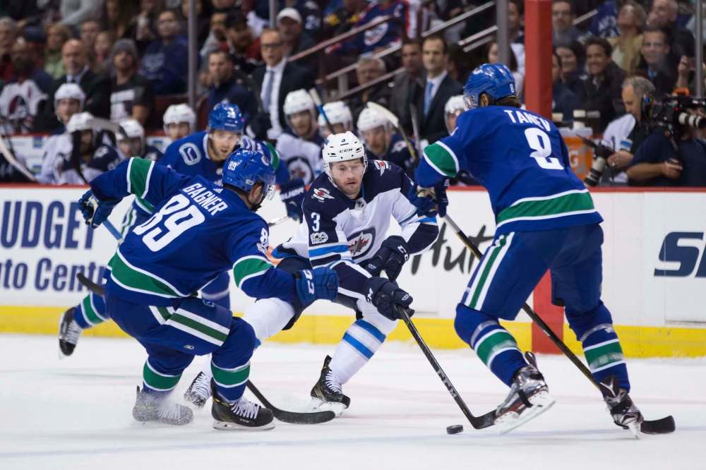 Darryl Dyck / The Canadian Press files
Jets defenceman Tucker Poolman (centre) played the second game of his NHL career on Thursday night against the Vancouver Canucks. Head coach Paul Maurice says Poolman ‘looked very mature and composed’ in his debut.
