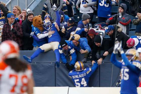 Winnipeg Blue Bombers' fans celebrate the TJ Heath (23) interception with Kevin Fogg (3) and Tristan Okpalaugo (54) during second half CFL action against the B.C. Lions, in Winnipeg, Saturday, October 14, 2017. THE CANADIAN PRESS/John Woods