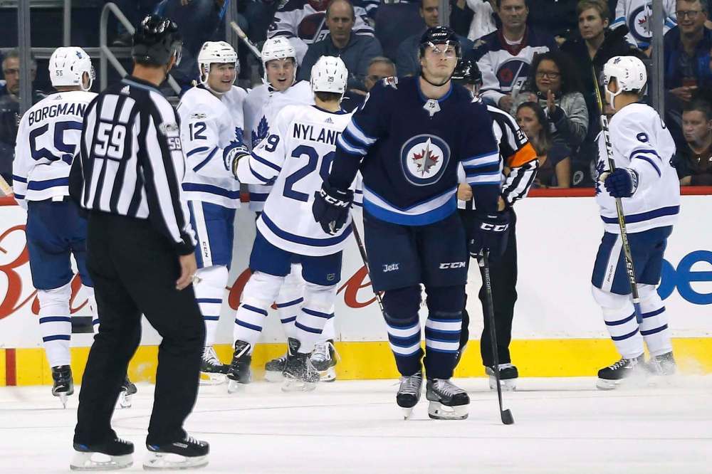 THE CANADIAN PRESS/John Woods
Toronto Maple Leafs' celebrate their goal against the Winnipeg Jets while Jacob Trouba looks on during second period NHL action in Winnipeg on Wednesday, October 4, 2017.