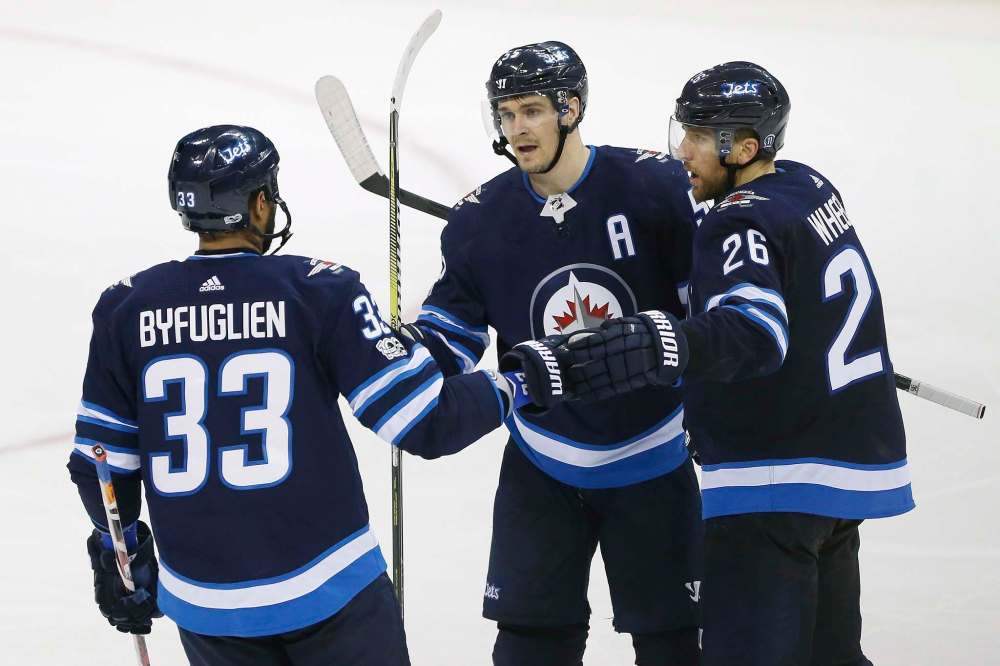 Winnipeg Jets defenceman Dustin Byfuglien (33) centre Mark Scheifele (55) and right wing Blake Wheeler (26) celebrate Scheifele's goal against the Pittsburgh Penguins during third period NHL action in Winnipeg on Sunday, October 29, 2017. THE CANADIAN PRESS/John Woods