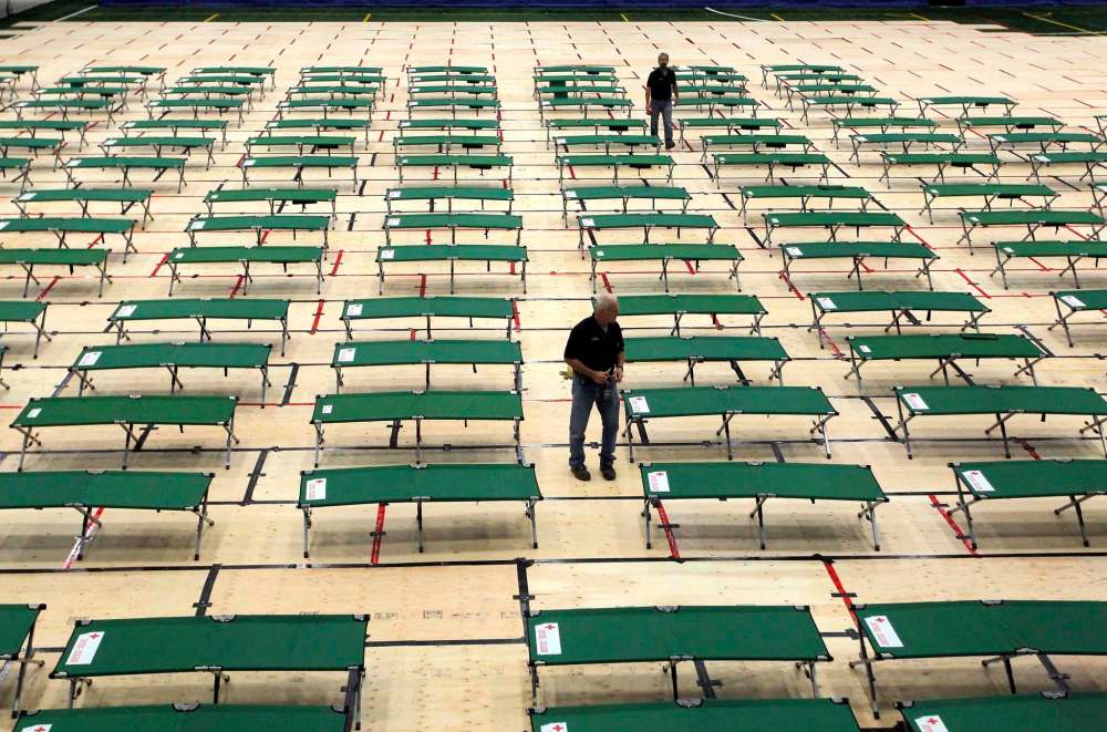 BORIS MINKEVICH / WINNIPEG FREE PRESS FILES
Red Cross workers set up cots in the Winnipeg Soccer Federation complex in September.