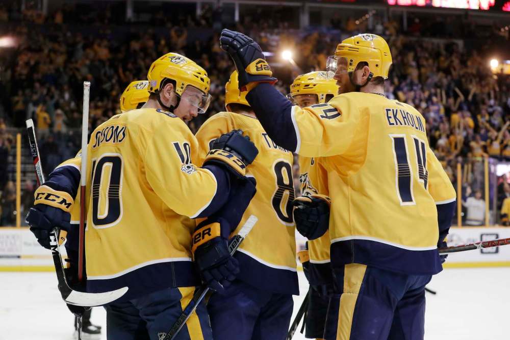 Nashville Predators center Kyle Turris (8) is congratulated by Colton Sissons (10) and Mattias Ekholm (14), of Sweden, after scoring a goal against the Winnipeg Jets in the second period of an NHL hockey game Monday, Nov. 20, 2017, in Nashville, Tenn. (AP Photo/Mark Humphrey)