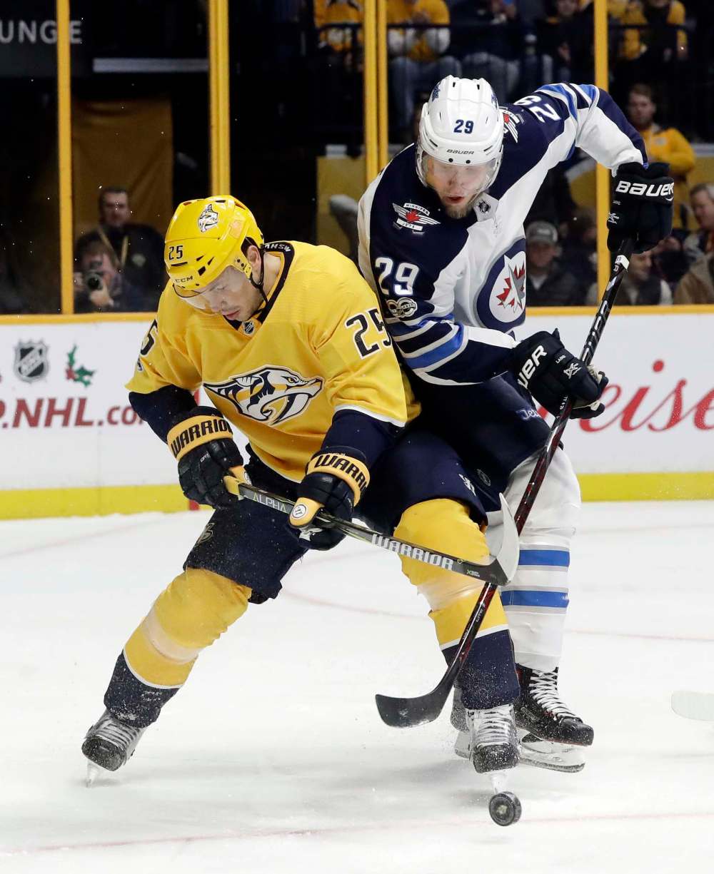 Nashville Predators defenseman Alexei Emelin (25), of Russia, and Winnipeg Jets right wing Patrik Laine (29), of Finland, battle for the puck in the first period of an NHL hockey game Monday, Nov. 20, 2017, in Nashville, Tenn. (AP Photo/Mark Humphrey)