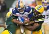 THE CANADIAN PRESS FILES/Jason Franson.
Harris is tackled by Edmonton Eskimos Cauchy Muamba and Deon Lacey during first half CFL action in Edmonton, in 2016.
