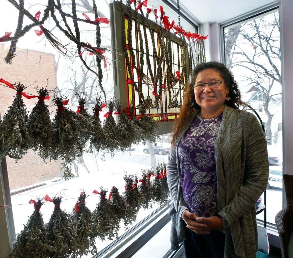 WAYNE GLOWACKI / WINNIPEG FREE PRESS
Ursula Summers stands by sweet grass and sage hanging in the meeting room of the Community Care Site at 443 Spence Street. Ursula first came to the centre as a mother trying to take care of her grandson. She is now employed at the centre.