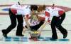 Jones throws her last rock as Jill Officer and Dawn McEwen sweep during the Olympic curling final at the Sochi Winter Olympics in 2014. (Adrian Wyld / The Canadian Press files)