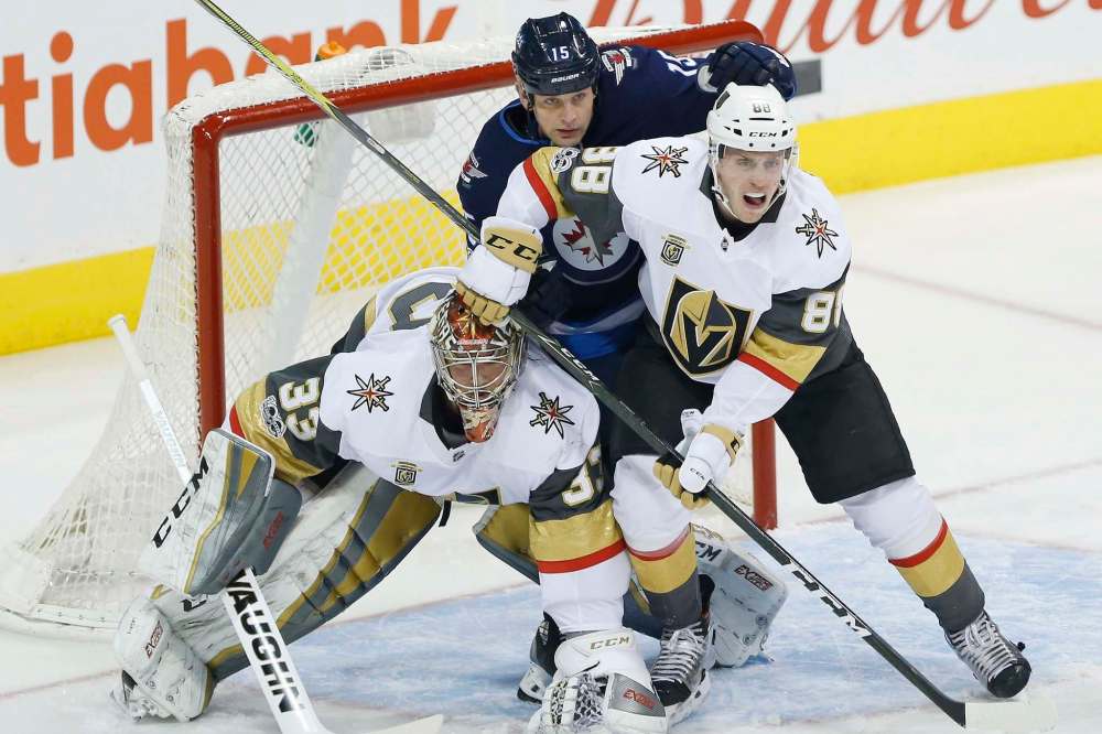 THE CANADIAN PRESS/John Woods
Winnipeg Jets' Matt Hendricks attempts to get an opening against Las Vegas Golden Knights goalie Maxime Lagace and Nate Schmidt during first period in Winnipeg, Friday.