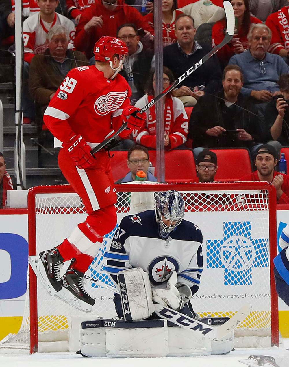 Winnipeg Jets goalie Connor Hellebuyck (37) stops a shot as Detroit Red Wings right wing Anthony Mantha (39) jumps in front of the net in the first period of an NHL hockey game Tuesday, Dec. 5, 2017, in Detroit. (AP Photo/Paul Sancya)